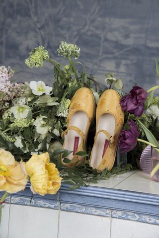 a pair of brocade markarian x vibi venezia flats in front of flowers