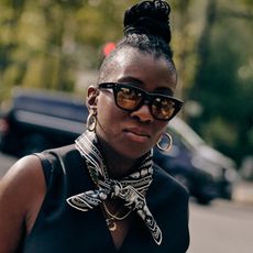 Nikki Ogunnaike wearing sunglasses, earrings, and a scarf 