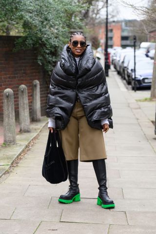 woman wearing puffer jacket, Bermuda shorts, and boots