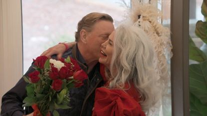 Suzanne (right) holds a bouquet of flowers as Avery (left) kisses her cheek, in &#039;The Later Daters.&#039;