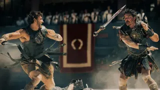 Two Roman warriors (Paul Mescal and Pedro Pascal) fight in the coliseum, in 'Gladiator II.'