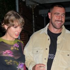 Taylor Swift wears a floral top and has a slightly red nose as she holds hands with boyfriend Travis Kelce