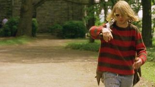 Michael Pitt as Blake wearing a red striped sweater walking down a wooded driveway in 'Last Days'