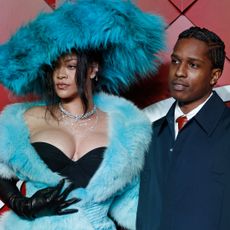 Rihanna on the fashion awards carpet with asap rocky wearing a fur hat and opera gloves