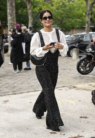 woman wearing embellished overalls and a sheer blouse