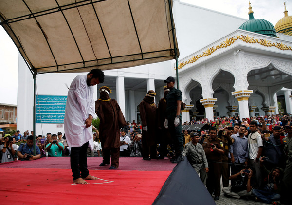 ▲印尼亞齊特區（Aceh）有2名男同志發生性行為，23日遭到公開鞭刑。（圖／路透社）