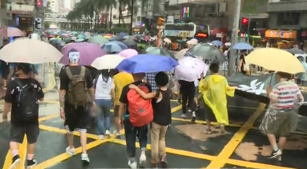 ▲▼民眾不畏風雨加入「反蒙面法」遊行。（圖／翻攝自香港電台視像新聞）