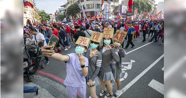 高雄罷韓、挺韓兩場活動拚場，反韓的年輕人特地到挺韓隊伍前自拍，比出小英競選連任的「3」號手勢。