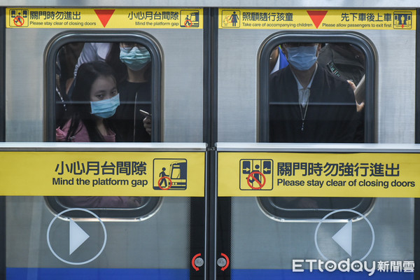 ▲新冠肺炎疫情升溫，搭乘捷運民眾戴口罩，但難拉出適當社交距離。（圖／記者林敬旻攝）