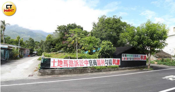 蔣家親屬認為，該建案的土地原可由右邊的道路進出，卻欺騙不識字的老人簽署同意使用左側的土地，因而在路口綁白布條抗議。（圖／記者趙世勳攝）