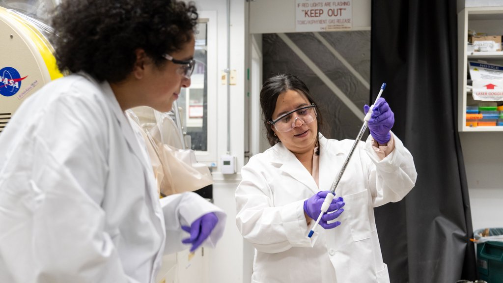 Cathy Trejo (right) shows off a tube filled with pebbles