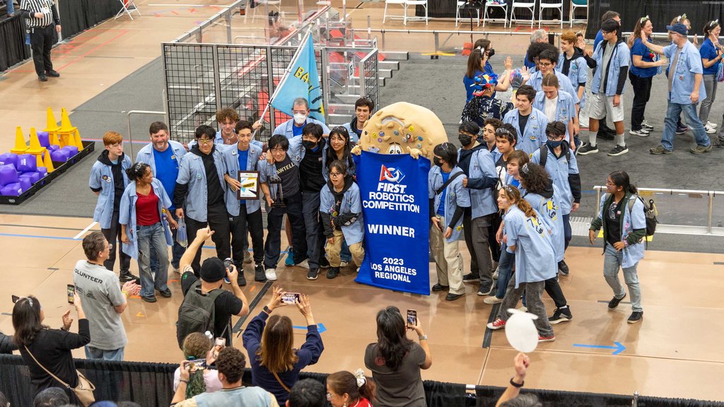 Part of the winning alliance, JPL-sponsored Team 702 (“Bagel Bytes”) from Culver City High School gathers beside their banner and a mascot in a bagel costume