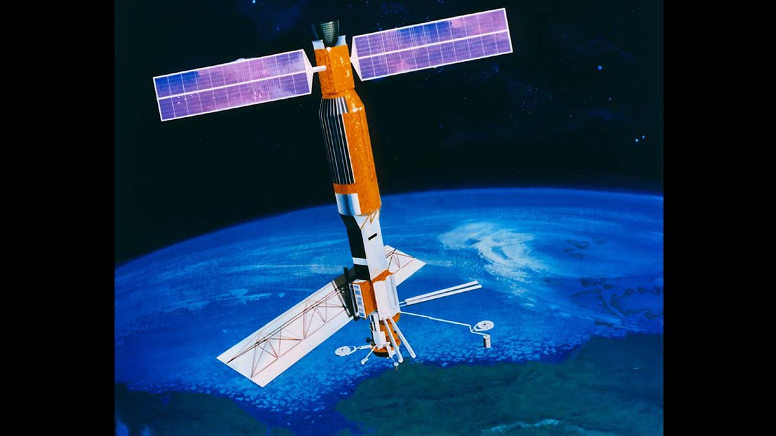 An illustration of the Seasat satellite orbiting in outer space, with stars in the background.