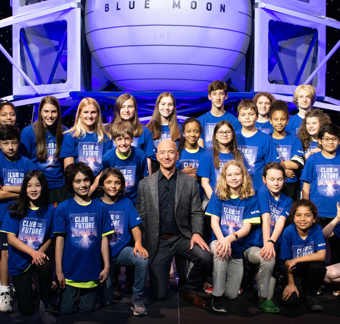 Blue Origin Founder Jeff Bezos poses with kids wearing Club for the Future t-shirts in front of the Blue Moon lunar lander.