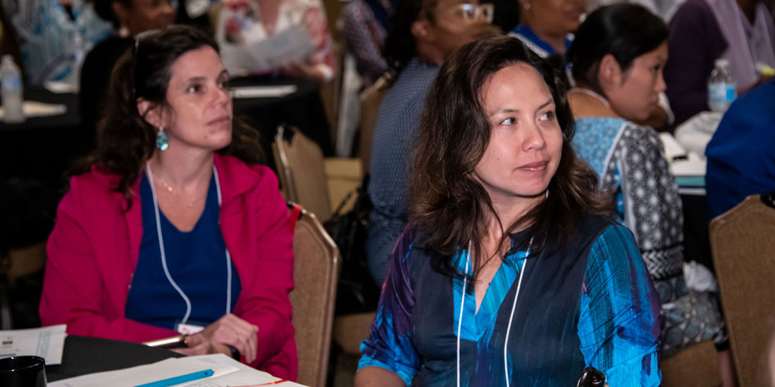 Two people posing for photo at EiC conference. Both are wearing glasses and are smiling.