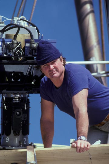 a worker in a blue shirt and beanie is positioned near machinery on a construction site