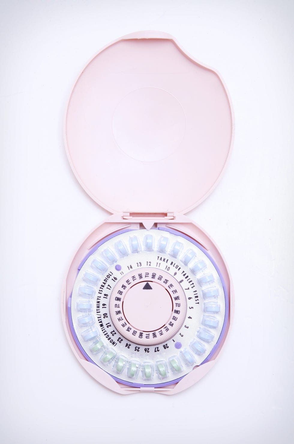 birth control pills and container on white background