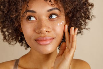 woman applying dots of skincare to face