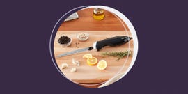 electric knife on cutting board with garlic lemon and rosemary