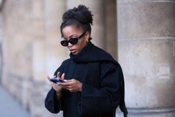 a woman checks her phone while wearing sunglasses to illustrate a guide to the best gifts on amazon of 2024