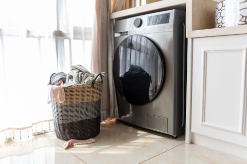 wicker laundry basket with clothes near washing machine