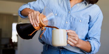 woman pouring coffee into mug from pour over coffee maker