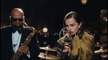 musicians performing on stage with a saxophone and microphone