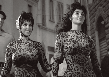 two figures walking in matching leopard print attire