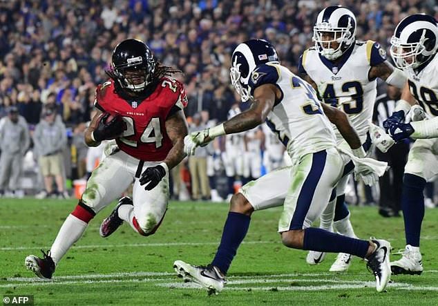 Running back Devonta Freeman of the Atlanta Falcons looks for space in front of cornerback Troy Hill of the Los Angeles Rams in their NFC Wild Card Playoff