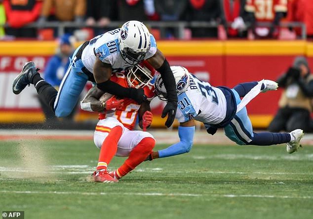 Tyreek Hill (C) of the Kansas City Chiefs is tackled by Brian Orakpo and Kevin Byard of the Tennessee Titans during the AFC Wild Card Playoff Game