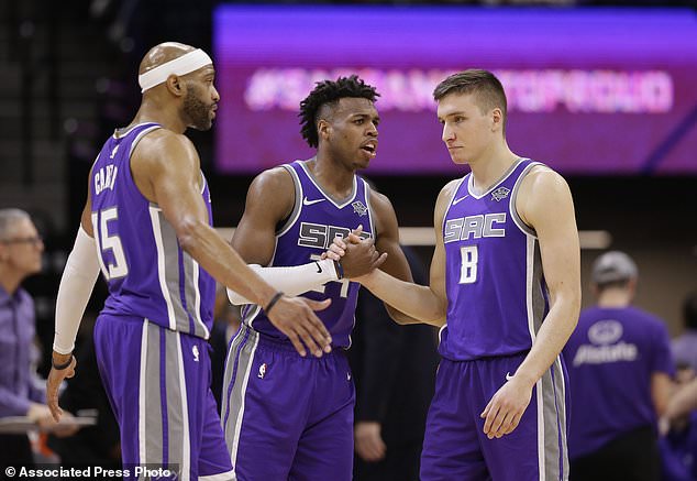 Sacramento Kings' Vince Carter, left, Buddy Hield, center, and Bogdan Bogdanovic begin to celebrate in the closing moments of the Kings' 106-98 win over the Denver Nuggets in an NBA basketball game Saturday, Jan. 6, 2018, in Sacramento, Calif. (AP Photo/Rich Pedroncelli)