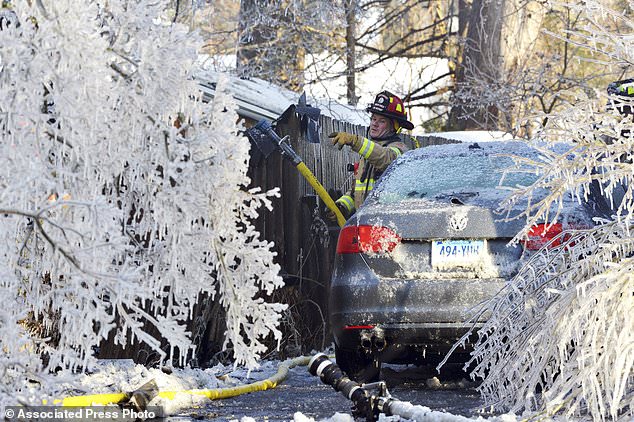 FILE - In this Jan. 5, 2018, file photo, a firefighter from the Longmeadow Fire Department battles a house fire in Longmeadow, Mass. Firefighters battling blazes in the extreme cold are faced with treacherous conditions, frozen hydrants and slick surfaces that make an already difficult job even harder. Departments in colder climates prepare months ahead for the coming freeze, readying equipment and changing how they approach fires in the coldest months. (Dave Roback/The Republican via AP, File)