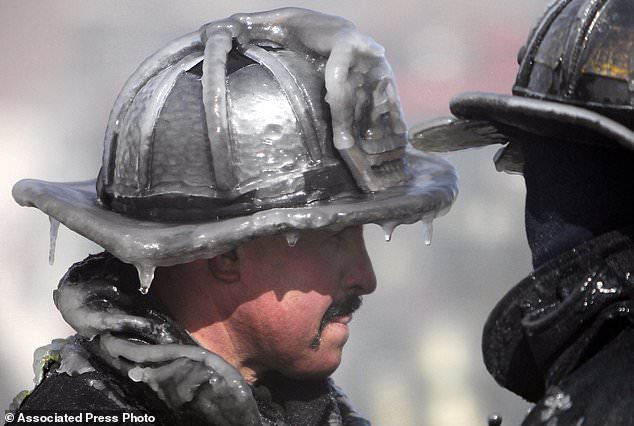 FILE- In this Feb. 12, 2012, file photo, a firefighter's helmet is caked in ice at the scene of a four-alarm fire in Boston. Cold-weather fire departments prepare months ahead for winter's coming freeze, readying equipment and changing how they approach fires in the coldest months. (AP Photo/Michael Dwyer, File)