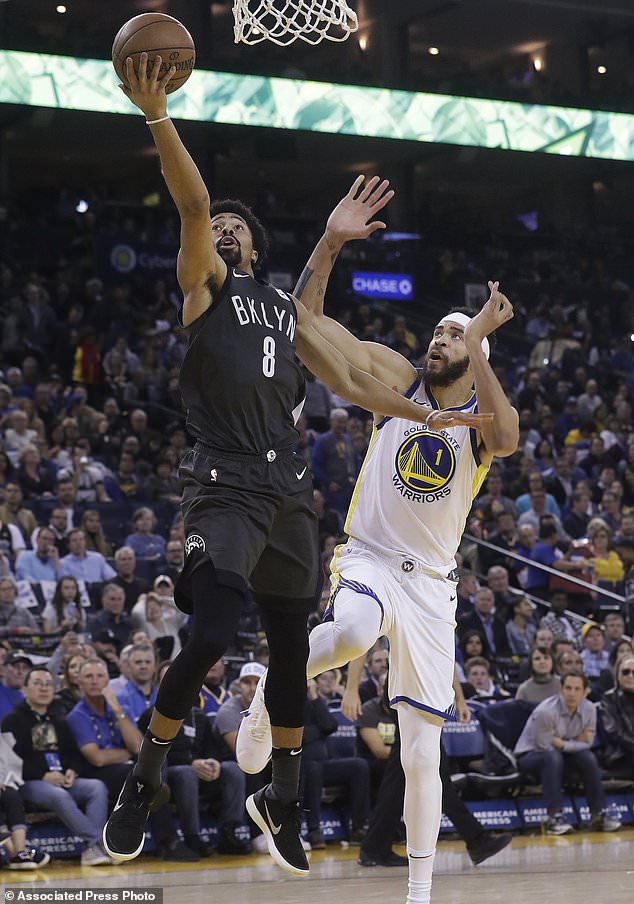 Brooklyn Nets guard Spencer Dinwiddie (8) shoots next to Golden State Warriors center JaVale McGee (1) during the second half of an NBA basketball game in Oakland, Calif., Tuesday, March 6, 2018. (AP Photo/Jeff Chiu)