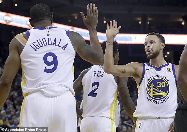 Golden State Warriors forward Andre Iguodala (9) and guard Stephen Curry (30) celebrate during the first half of the team's NBA basketball game against the Brooklyn Nets in Oakland, Calif., Tuesday, March 6, 2018. (AP Photo/Jeff Chiu)