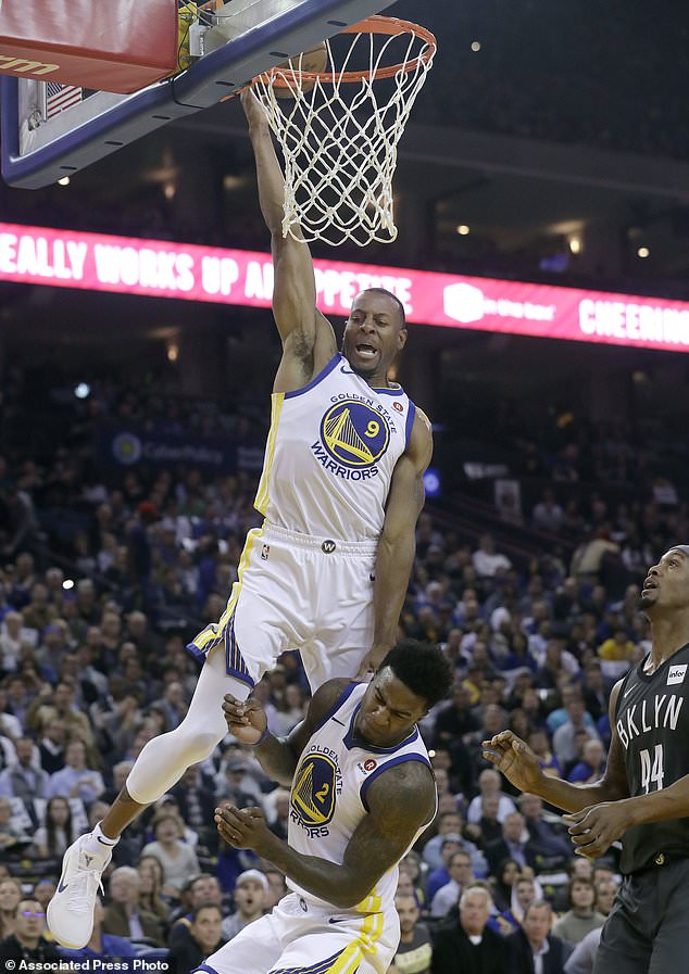 Golden State Warriors forward Andre Iguodala (9) shoots over teammate Jordan Bell (2) and in front of Brooklyn Nets forward Dante Cunningham (44) during the first half of an NBA basketball game in Oakland, Calif., Tuesday, March 6, 2018. (AP Photo/Jeff Chiu)