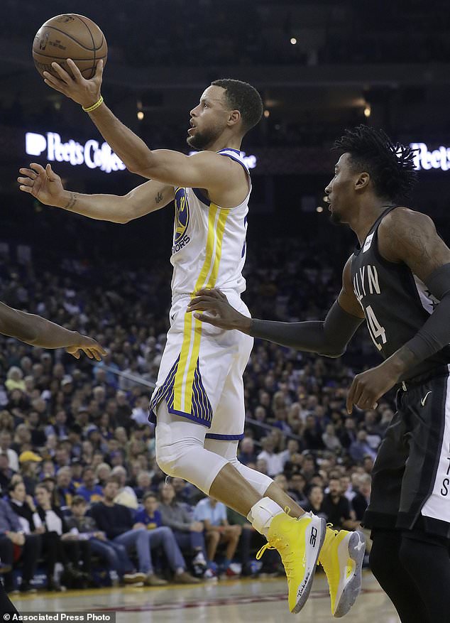 Golden State Warriors guard Stephen Curry, left, shoots in front of Brooklyn Nets forward Rondae Hollis-Jefferson during the first half of an NBA basketball game in Oakland, Calif., Tuesday, March 6, 2018. (AP Photo/Jeff Chiu)