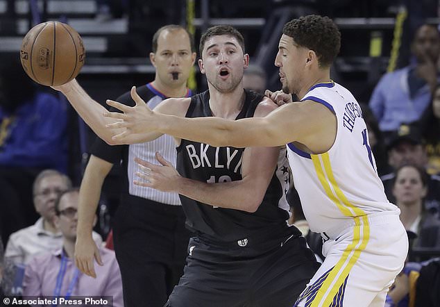 Brooklyn Nets forward Joe Harris, left, passes as Golden State Warriors guard Klay Thompson defends during the first half of an NBA basketball game in Oakland, Calif., Tuesday, March 6, 2018. (AP Photo/Jeff Chiu)