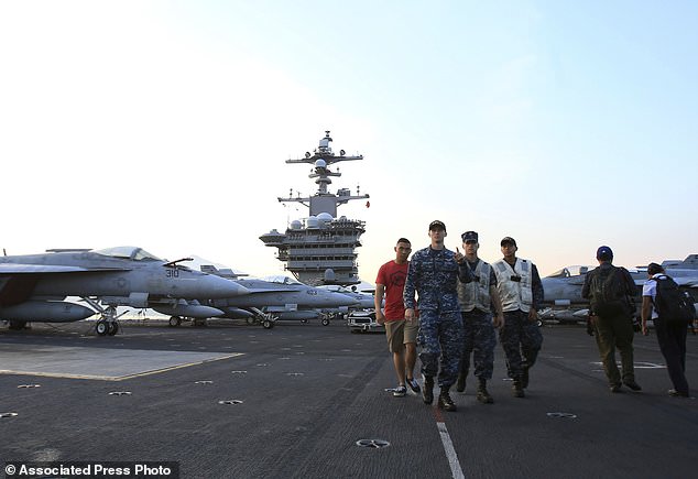 American navy officers walk aboard the aircraft carrier USS Carl Vinson as it docks in Danang bay, Vietnam on Monday, March 5, 2018. For the first time since the Vietnam War, a U.S. Navy aircraft carrier is paying a visit to a Vietnamese port, seeking to bolster both countries' efforts to stem expansionism by China in the South China Sea. (AP Photo/ Hau Dinh)