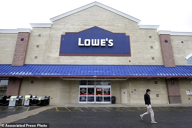 FILE- In this Feb. 23, 2018, file photo a passer-by walks near an entrance to a Lowe's retail home improvement and appliance store, in Framingham, Mass. Lowe's Companies Inc. reports earnings on Wednesday, May 23. (AP Photo/Steven Senne, File)