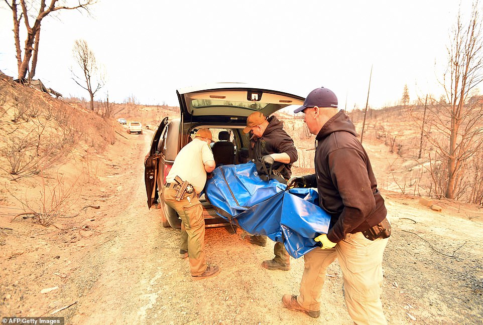 Yuba and Butte County Sheriff officers are seen loading a body into a hearse in Concow, California 