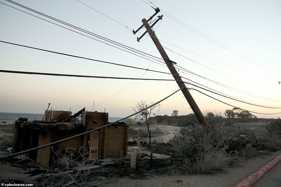 A telegraph pole which has partly collapsed after being damaged by flame which torched the neighboring building in Malibu