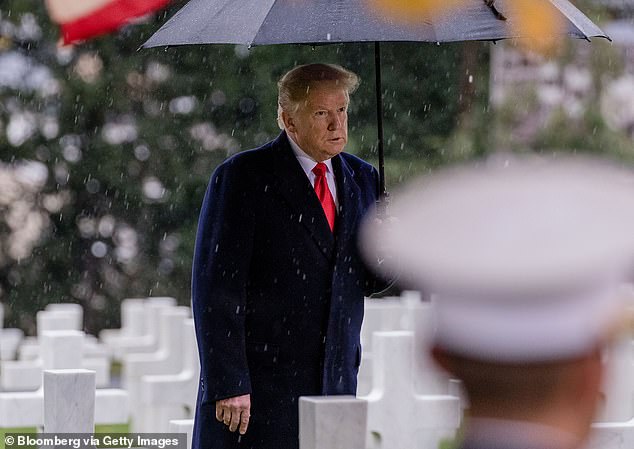 U.S. President Donald Trump shelters under an umbrella during the American Commemoration Ceremony at the Suresnes American Cemetery in Paris, France, on Sunday, Nov. 11, 2018. Trump spoke at a military cemetery near Paris, a day after drawing sharp criticism for canceling a trip to a separate cemetery during centenary commemorations of the end of World War I