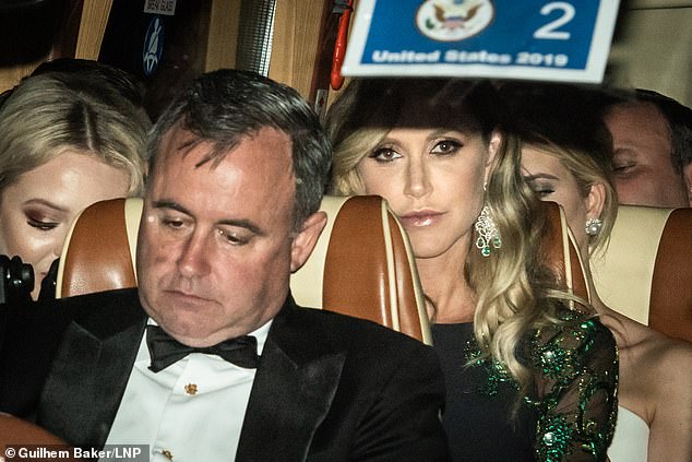 Tired: Lara stared ahead while Tiffany and Ivanka appeared to be looking down at their phones as they rolled away from the US ambassador's residence following a dinner hosted by Donald Trump and wife Melania