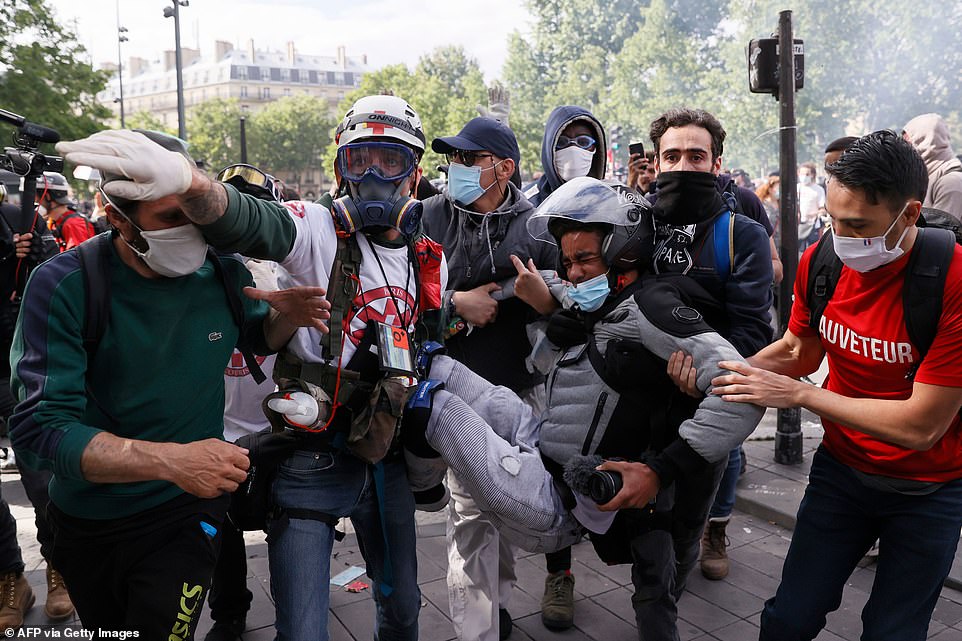 A vast crowd had hoped to march in memory of Adama Traoré, a 24-year-old black Frenchman of Malian origin who died police custody in July 2016. Pictured: An injured demonstrator is helped away as people gather during the rally