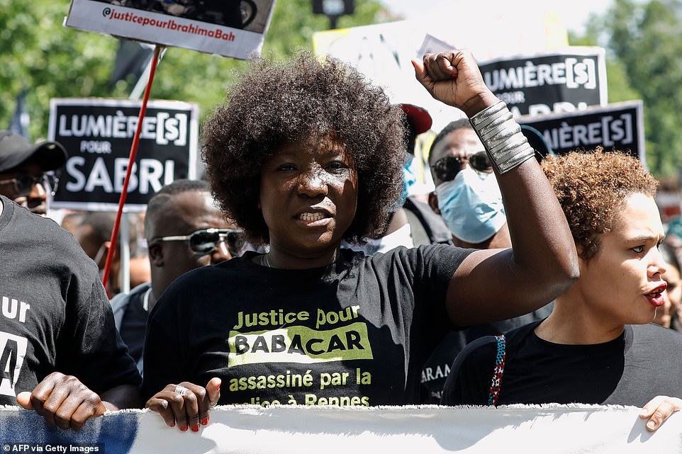 Awa Gueye, the sister of Babacar Gueye who died in 2015, raises her fist during a rally as part of the 'Black Lives Matter' worldwide protests against racism and police brutality on Place de la Republique in Paris