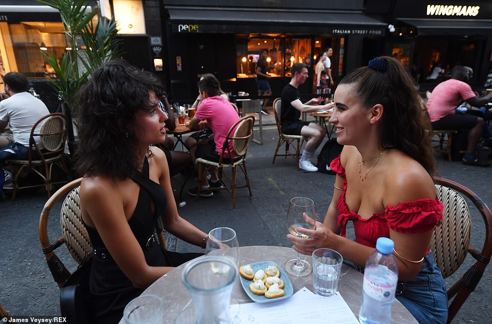 Diners sit outside on Old Compton Street in London's Soho yesterday evening as the Eat Out to Help Out scheme continues