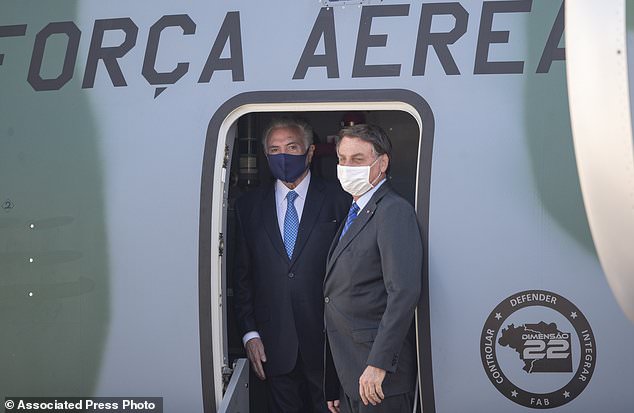 Brazilian President Jair Bolsonaro, right, and former President Michel Temer stand in the plane carrying humanitarian aid that will be sent to Lebanon, including medical supplies and experts to assist in the wake of the explosion in Beirut, at the Air Force base in Guarulhos, greater Sao Paulo area, Brazil, Wednesday, Aug. 12, 2020. Temer, whose parents were Lebanese, lead a group of 13 people that includes politicians, military personnel, and businessmen in delivering the aid. (AP Photo/Andre Penner)