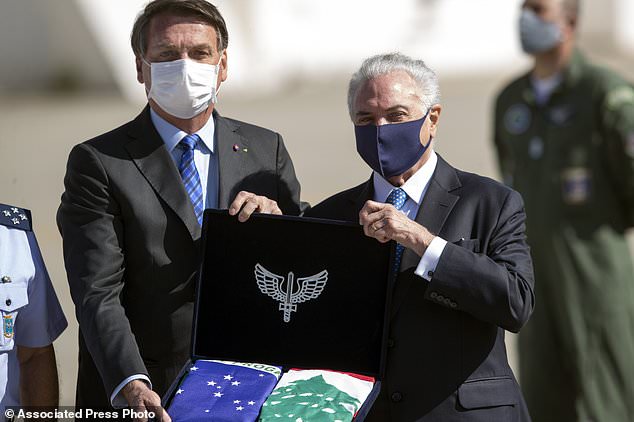 Brazilian President Jair Bolsonaro, left, and former President Michel Temer attend a ceremony to send off a planeload of humanitarian aid to Lebanon, including medical supplies and experts to assist in the wake of the explosion in Beirut, at the Air Force base in Guarulhos, greater Sao Paulo area, Brazil, Wednesday, Aug. 12, 2020. (AP Photo/Andre Penner)