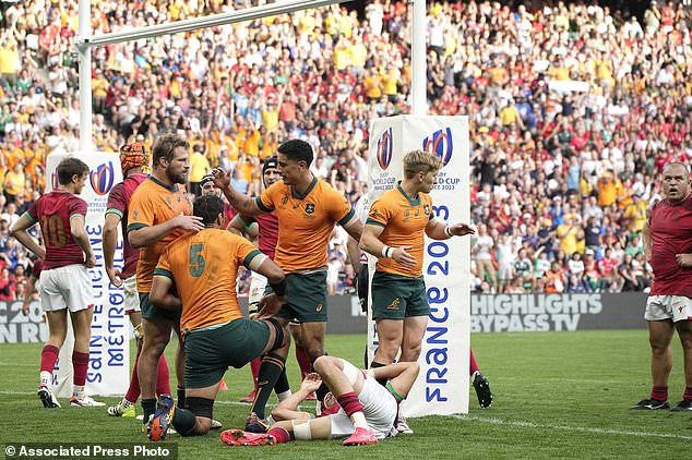 Australia's Richard Arnold celebrates with his teammates scoring a try during the Rugby World Cup Pool C match between Australia and Portugal at the Stade Geoffroy Guichard in Saint-Etienne, France, Sunday, Oct. 1, 2023. (AP Photo/Laurent Cipriani)